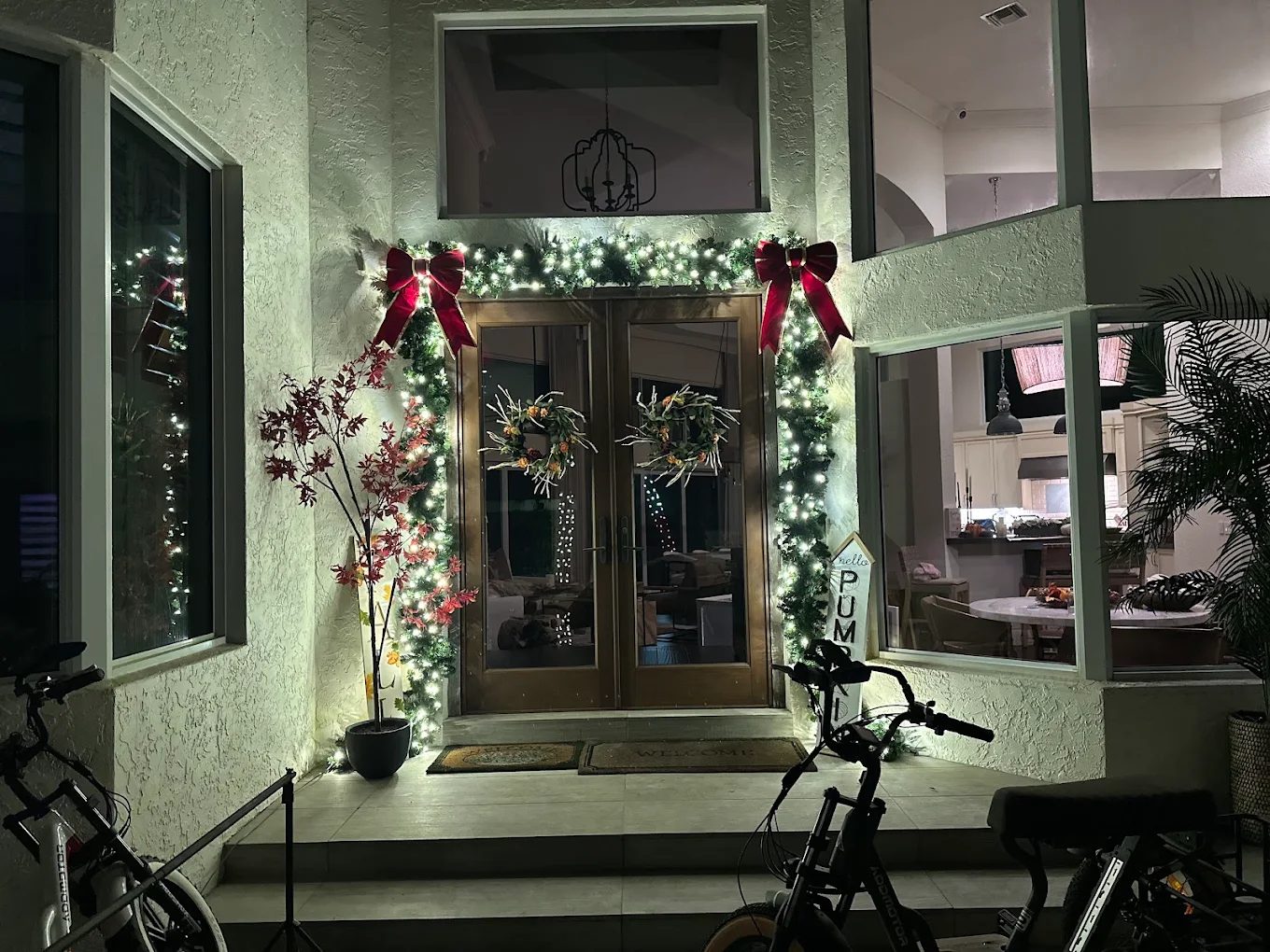 Entrance framed with lit garland and wreaths