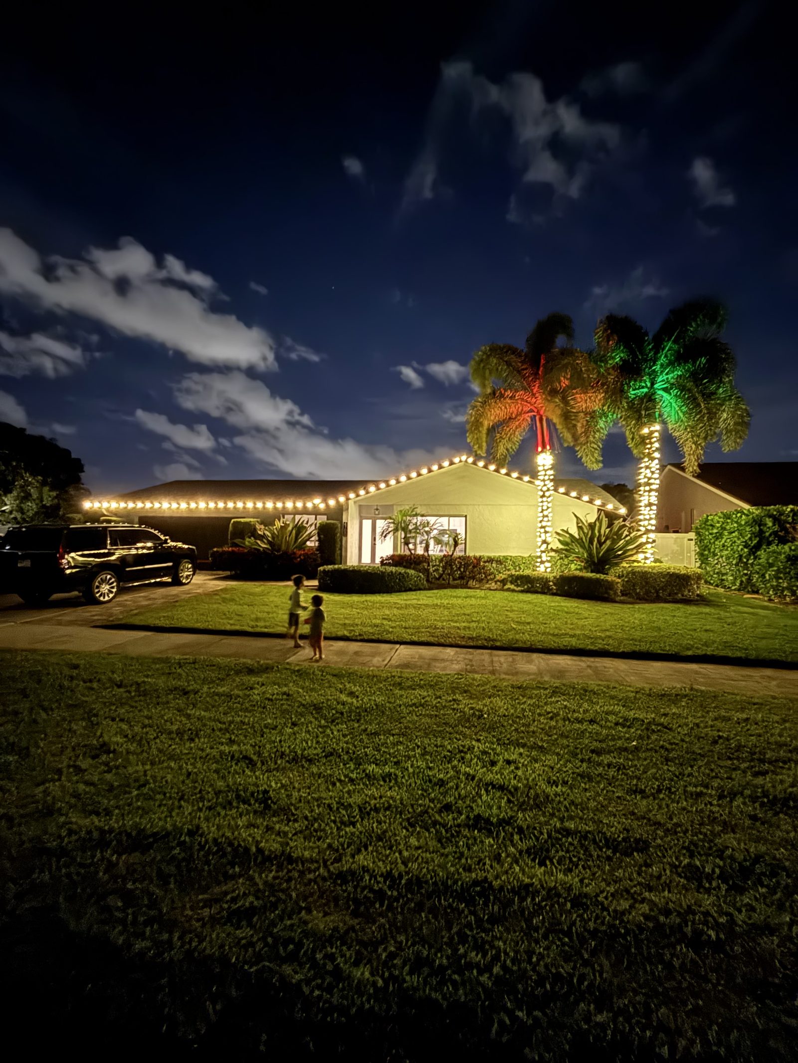 Tile-roof home with wreath and red-lit palms