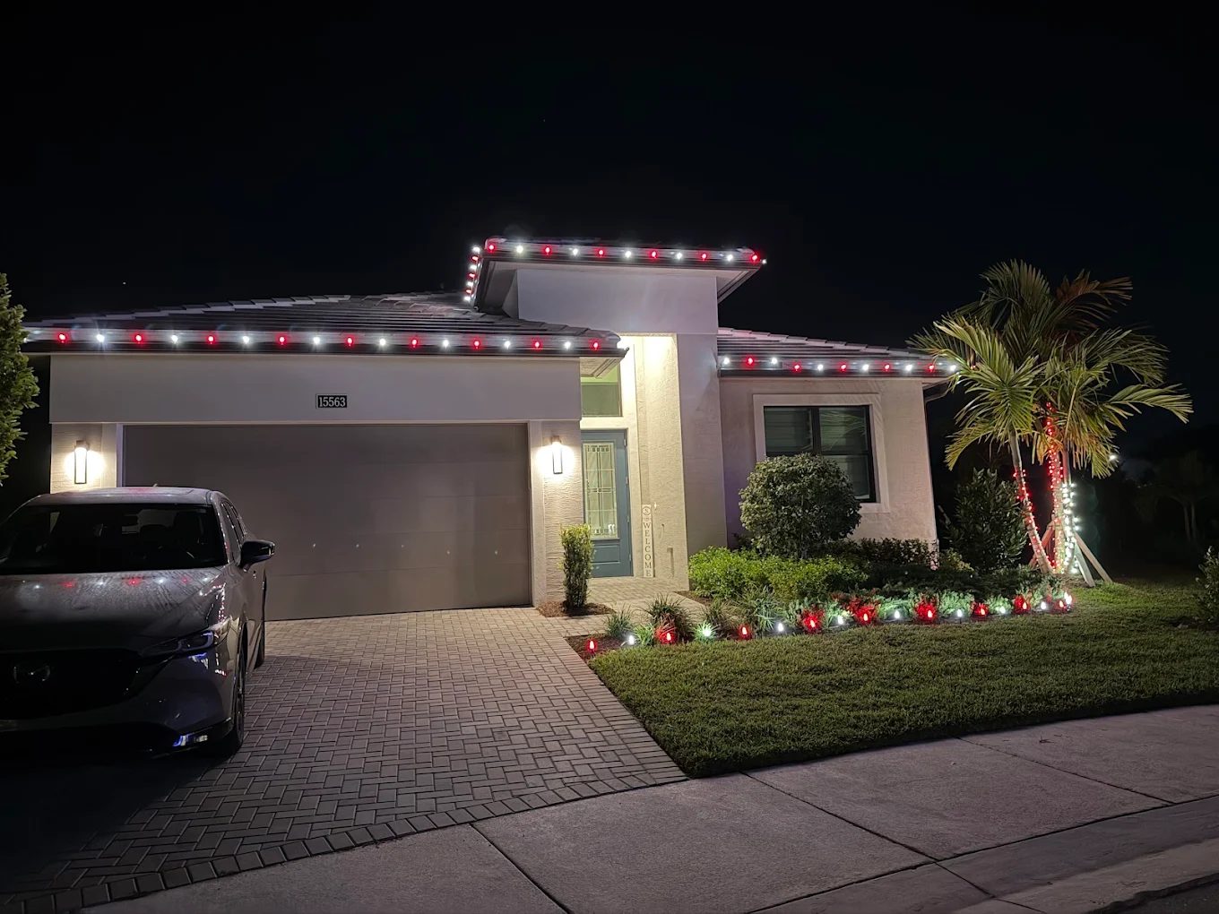 Warm white roofline lighting with wrapped palm