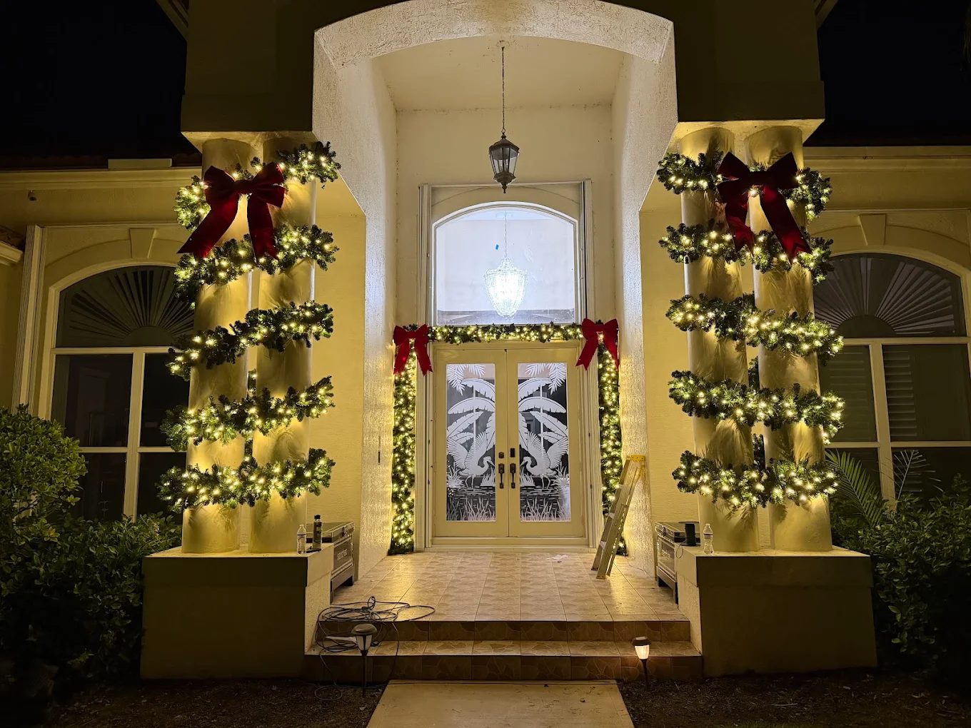 Columns wrapped in lit garland with red bows