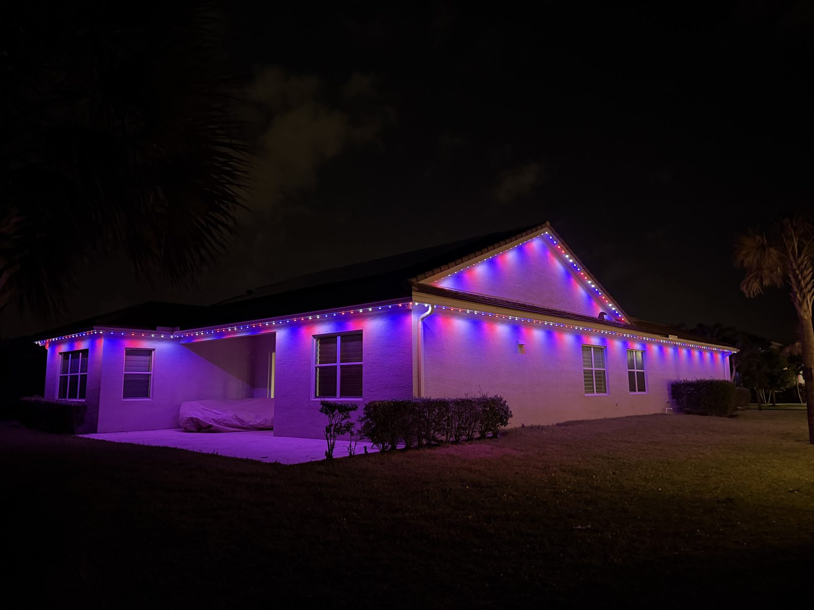 Two-story home with blue and green permanent lighting