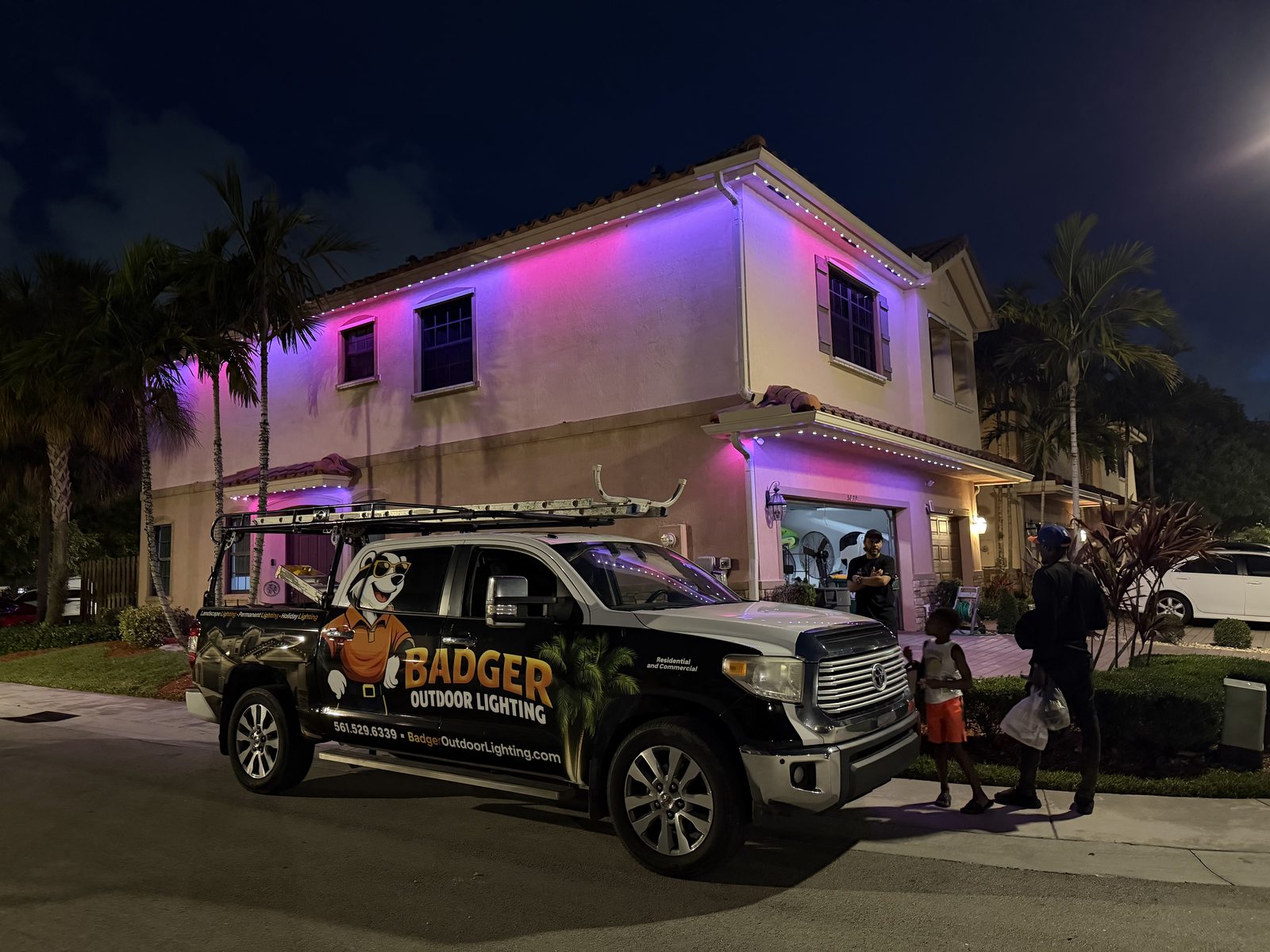 Two-story home with purple permanent uplighting