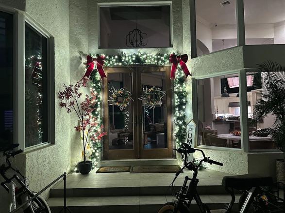 Entrance framed with lit garland and wreaths