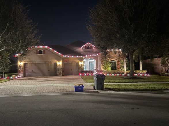 Home with crisp red and white roofline holiday lights