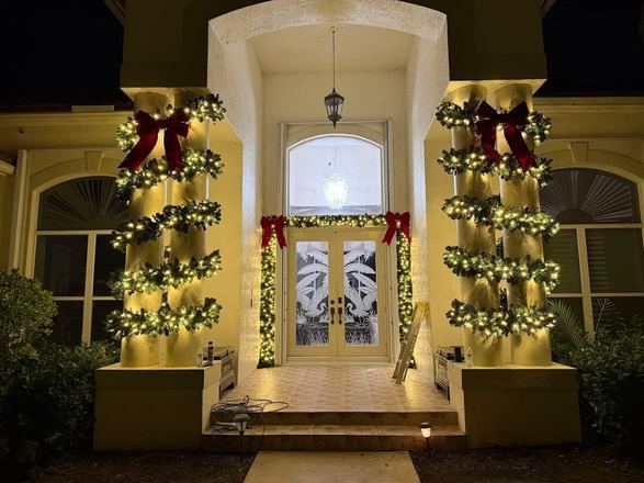 Columns wrapped in lit garland with red bows