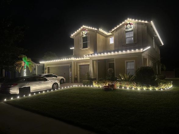 Home with green-lit palms and roofline lighting